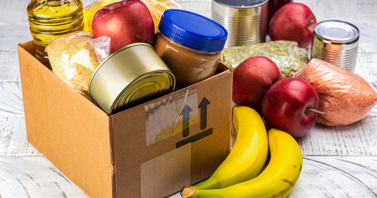 food from a pantry program. box and table filled with fruits, dry goods, and canned goods.